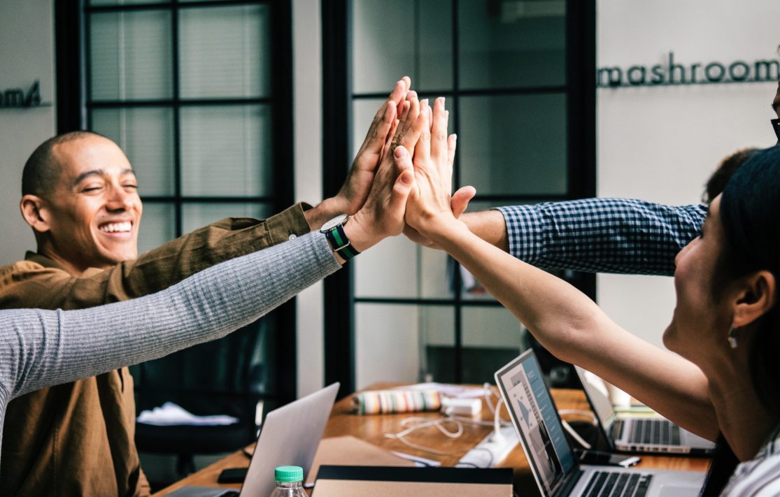 Four adults high fiving each other