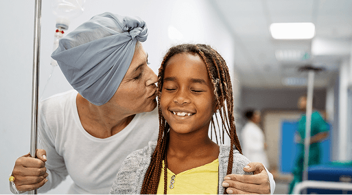 A cancer patient kissing her daughter on the cheek