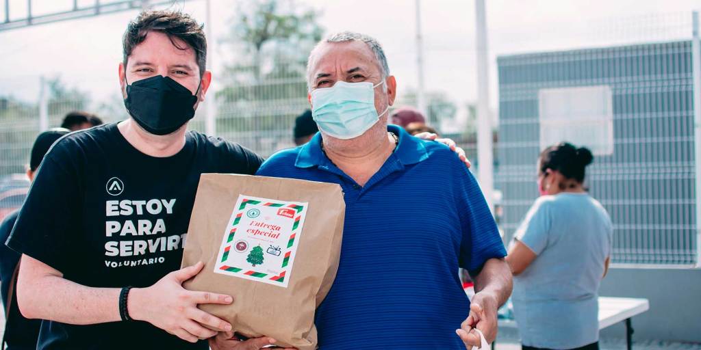 A volunteer handing a donation bag to an individual