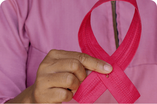 A person holding a pink breast cancer ribbon
