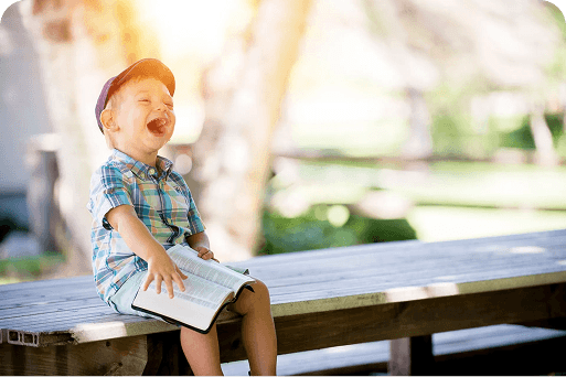 Child smiling on a park bench