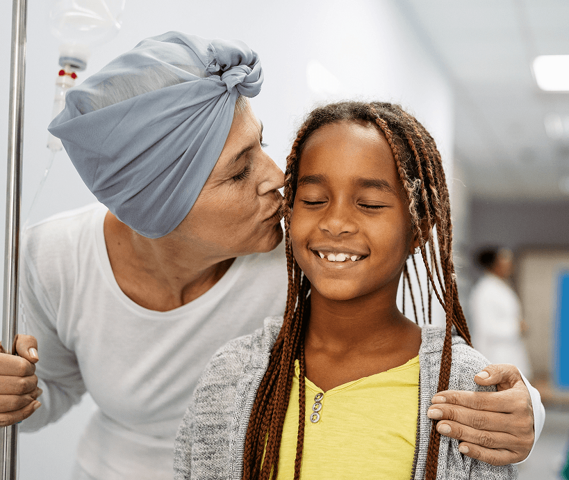 Cancer patient kissing her daughter on the cheek