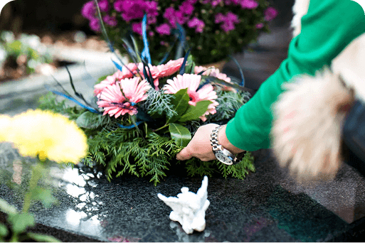 A person laying flowers on a gravesite