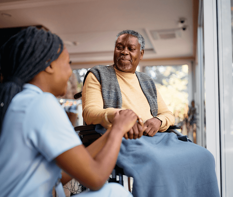 A patient holding hands with a health care worker