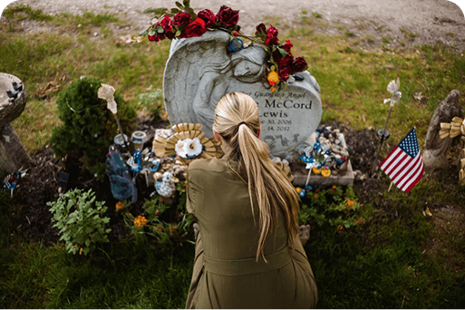 A woman standing by a gravesite