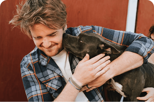 An owner hugging his dog