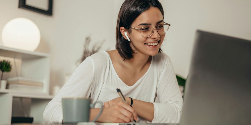 Una mujer que sonríe mientras escribe una carta