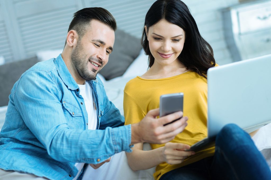 Pareja relajada mira fotos en un teléfono inteligente