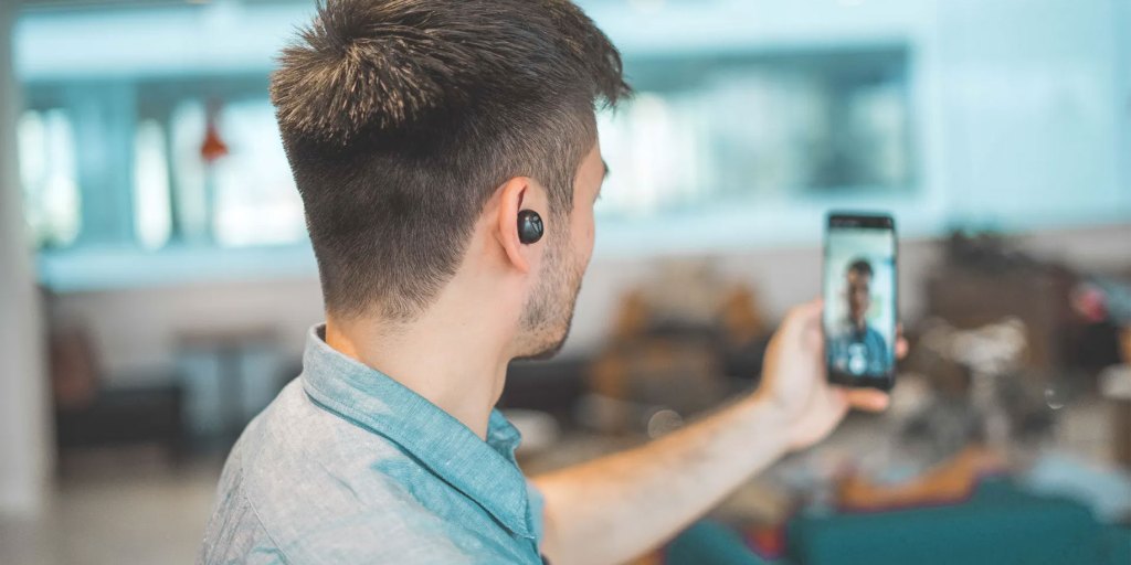 Um homem a filmar um vídeo com o seu telemóvel